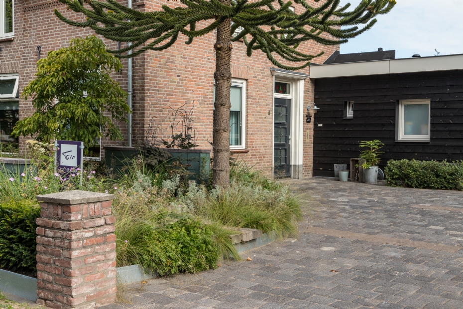 a zinc edging marks the boundary between the front yard and driveway of this robust garden designed by tom poppelaars.