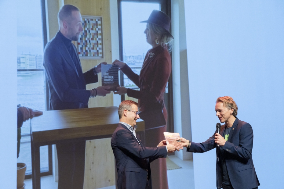 Gert-Jan Nabuurs receives the first copy of 'The Timber Truth'. In the background: Queen Máxima receives a copy during the opening of SAWA in Rotterdam